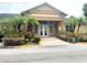 Inviting clubhouse entrance with double doors, palm trees, and well-maintained landscaping at 2424 Barley Club Ct # 8, Orlando, FL 32837