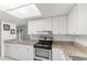 Bright kitchen featuring granite countertops, white cabinets, and modern stainless steel appliances at 2424 Barley Club Ct # 8, Orlando, FL 32837