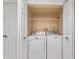Bright laundry closet featuring a stacked washer and dryer with built-in shelving for added storage at 2424 Barley Club Ct # 8, Orlando, FL 32837