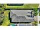 Aerial view of roof and surrounding property, lush landscaping, pool, and solar panels at 246 Tomelloso Way, Davenport, FL 33837