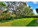 Beautifully kept backyard features lush green grass, manicured hedges, and mature trees at 246 Tomelloso Way, Davenport, FL 33837