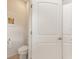Half bath with a white toilet and tiled floor, enhanced by a flamingo picture at 246 Tomelloso Way, Davenport, FL 33837