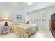 Light and airy bedroom with floral bedding, shuttered window, and neutral decor at 246 Tomelloso Way, Davenport, FL 33837
