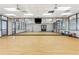 Dance studio with wood floor, mirrors, television, and bright lighting, perfect for fitness classes and practices at 246 Tomelloso Way, Davenport, FL 33837