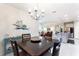 Open concept dining room with chandelier, wood table and view of the living room and kitchen at 246 Tomelloso Way, Davenport, FL 33837