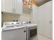 Bright laundry room with modern washer and dryer, ample storage, and tile flooring at 246 Tomelloso Way, Davenport, FL 33837