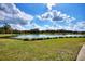 Scenic view of a grassy pond with a clear sky reflecting on the water's surface at 246 Tomelloso Way, Davenport, FL 33837