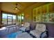 Covered porch with outdoor seating, ceiling fan, and views of lush landscaping at 246 Tomelloso Way, Davenport, FL 33837