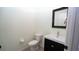 Half bathroom featuring tile floors, dark vanity, toilet, and modern mirror at 3199 Turret Dr, Kissimmee, FL 34743