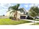 Two-story home featuring a two-car garage, manicured lawn, and mature trees at 3199 Turret Dr, Kissimmee, FL 34743