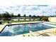Backyard pool overlooking a tranquil lake, enhanced by greenery and blue skies at 3199 Turret Dr, Kissimmee, FL 34743