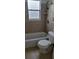 Cozy bathroom featuring neutral tiles, a bathtub, and a built-in shelf for storage at 332 Carolina Ave, St Cloud, FL 34769