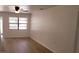 Bright living room with updated flooring, a ceiling fan, and a large window for natural light at 332 Carolina Ave, St Cloud, FL 34769