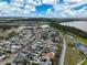 Wide aerial view of a neighborhood next to a big lake, lush green spaces, and meandering pathways at 3329 Schoolhouse Rd, Harmony, FL 34773
