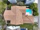 Top-down shot showcasing a private backyard pool and well-maintained landscaping next to a home with a classic brick roof at 3329 Schoolhouse Rd, Harmony, FL 34773