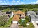 Aerial image of a home with a large, fenced backyard pool surrounded by palm trees, creating a private oasis near a tranquil lake at 3329 Schoolhouse Rd, Harmony, FL 34773