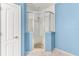 Bathroom with a glass shower, blue walls, and tile floors at 3329 Schoolhouse Rd, Harmony, FL 34773