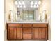Double sink vanity with wooden cabinets and a large mirror at 3329 Schoolhouse Rd, Harmony, FL 34773