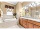 Bathroom boasts a soaking tub, tiled walls, and bright lighting at 3329 Schoolhouse Rd, Harmony, FL 34773