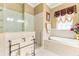 Beautiful bathroom with a tub, large glass shower, decorative tiles, and a window at 3329 Schoolhouse Rd, Harmony, FL 34773