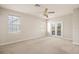 Bright bedroom featuring a ceiling fan, multiple windows, and access to private balcony at 3329 Schoolhouse Rd, Harmony, FL 34773