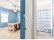 Nautical-themed bedroom featuring blue walls, white bedframe, and striped bedding, viewed from the bathroom doorway at 3329 Schoolhouse Rd, Harmony, FL 34773