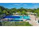 Inviting community pool area with ample seating, lush palm trees, and shade structures for relaxation at 3329 Schoolhouse Rd, Harmony, FL 34773
