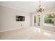 Expansive living room featuring tiled floors, chandelier lighting and access to the lanai and views of the pool at 3329 Schoolhouse Rd, Harmony, FL 34773