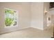 Bright, empty living room, with a window overlooking lush foliage and tile floors at 3329 Schoolhouse Rd, Harmony, FL 34773
