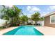 Full view of the luxurious pool with a water feature, mature landscaping and a beautiful backyard at 3329 Schoolhouse Rd, Harmony, FL 34773