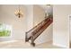 Sunlit foyer showcasing staircase with wood banister and chandelier at 3329 Schoolhouse Rd, Harmony, FL 34773