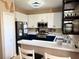 Bright kitchen with stainless steel appliances, open shelving, breakfast bar, and tile floors at 3491 Allegra Cir, St Cloud, FL 34772