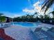 Community pool with sun loungers, tables and chairs under a bright blue sky at 3491 Allegra Cir, St Cloud, FL 34772