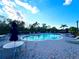Community pool featuring lounge chairs, tables, umbrellas and blue skies at 3491 Allegra Cir, St Cloud, FL 34772