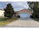 Charming single-story home with a two-car garage and well-maintained front yard and mature trees at 350 Chelmsford Ct, Kissimmee, FL 34758