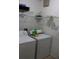 A compact laundry room featuring a washer, dryer, and shelving for storage at 350 Chelmsford Ct, Kissimmee, FL 34758