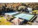 Aerial view of tennis courts, with a clubhouse, and mature trees at 466 Club Dr, Winter Springs, FL 32708