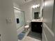 Well-lit bathroom featuring a shower-tub combination with frosted glass doors, toilet, vanity and updated fixtures at 4740 Tribute Trl, Kissimmee, FL 34746