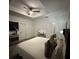 Spacious primary bedroom features tray ceiling, ceiling fan, and stylish decor at 4740 Tribute Trl, Kissimmee, FL 34746