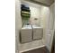 Functional laundry room equipped with a washer, dryer, shelving and storage space for cleaning supplies and luggage at 4740 Tribute Trl, Kissimmee, FL 34746