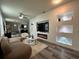 Bright and airy living room featuring a large TV, decorative shelving, comfortable seating and hardwood flooring at 4740 Tribute Trl, Kissimmee, FL 34746
