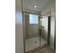 Modern walk-in shower featuring sleek glass door, and tiled walls with built-in shelving at 4740 Tribute Trl, Kissimmee, FL 34746