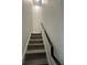 Staircase featuring wood stairs and dark handrail, providing a modern and functional design at 4740 Tribute Trl, Kissimmee, FL 34746