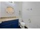 Bathroom featuring a blue vanity with light countertops, toilet, and nautical themed decorations at 4959 Tennessee Lake Dr, Auburndale, FL 33823