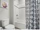 Bathroom showcasing a toilet, bathtub with shower, and black and white shower curtain at 4959 Tennessee Lake Dr, Auburndale, FL 33823