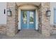 Front entry featuring a glass paneled double door with stone surround and sconce lighting at 4959 Tennessee Lake Dr, Auburndale, FL 33823