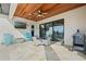 Covered outdoor patio with ceiling fan, table set and outdoor television with view of a putting green at 4959 Tennessee Lake Dr, Auburndale, FL 33823