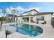Backyard infinity pool with connecting hot tub and outdoor patio area with furniture and a grill at 4959 Tennessee Lake Dr, Auburndale, FL 33823