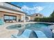 Infinity pool and spa with blue lounge chairs against a blue sky background at 4959 Tennessee Lake Dr, Auburndale, FL 33823