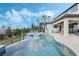 Backyard infinity pool with spa, sun loungers, and outdoor patio area with mounted television at 4959 Tennessee Lake Dr, Auburndale, FL 33823
